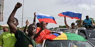 Supporters of the junta wave Russian flags as they demonstrate in Niger’s capital Niamey